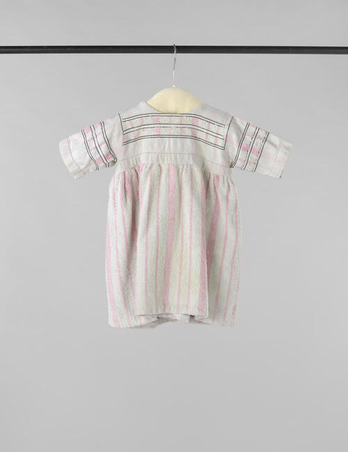 Kinderjurk met korte mouw, gemaakt van een wit-roze gestreepte badstoffen handdoek, op het lijf…